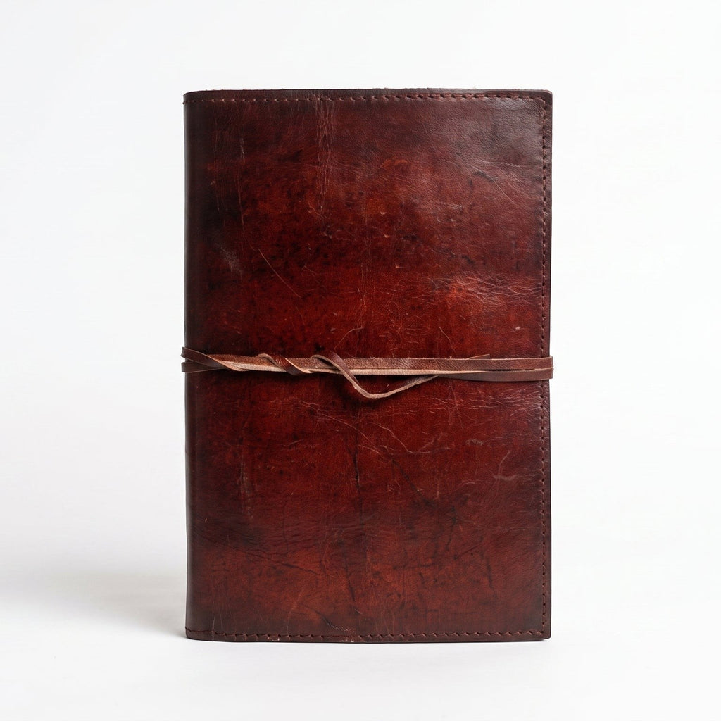 Retkatha cognac brown buffalo leather journal with a wrap-around strap closure and rustic hand-stitched finish.